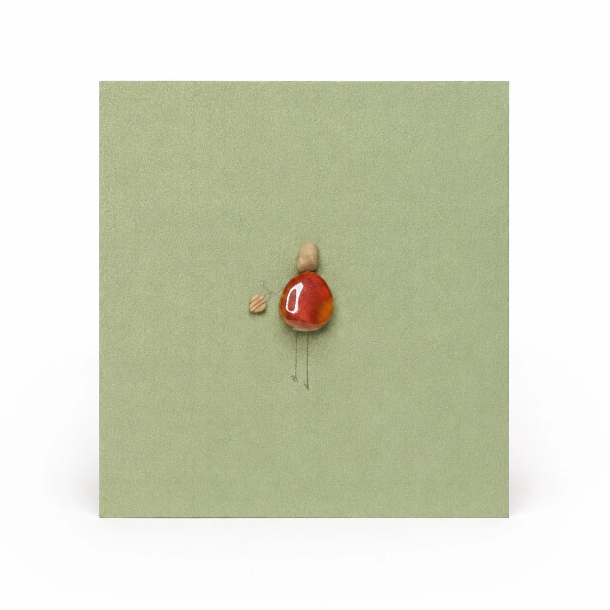 Green handmade greeting card featuring a pebble figure holding a tiny gift