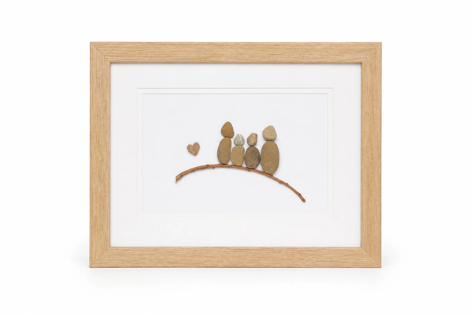 Pebble family portrait on a branch with wooden heart accent
