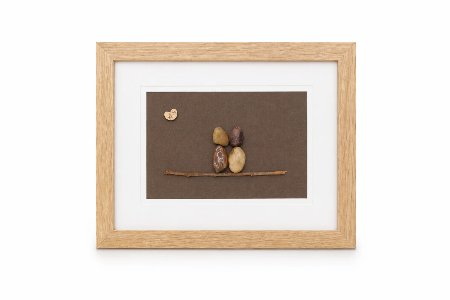 Pebble family sitting on tree branches with wooden hearts