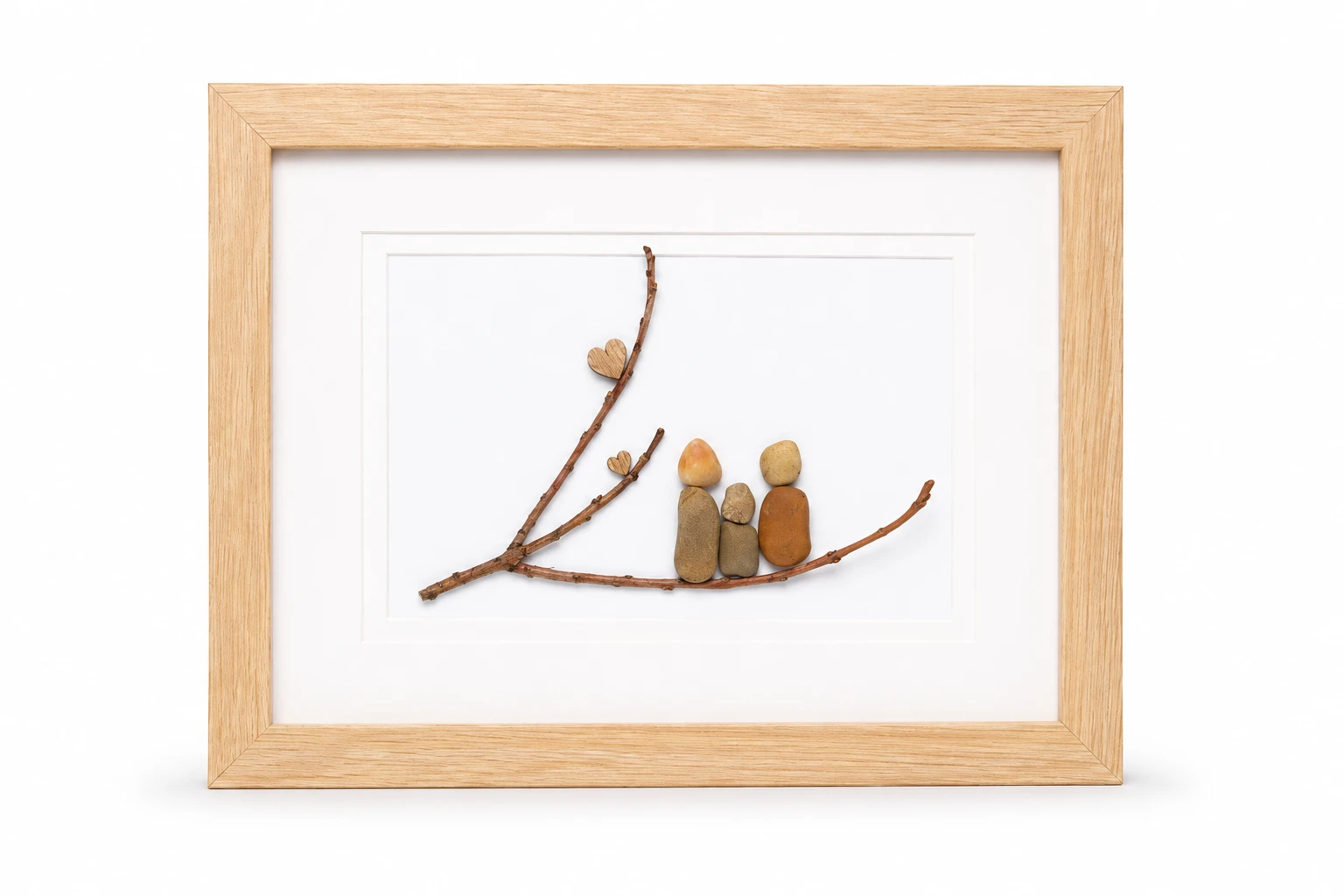 Close-up of a handmade pebble family artwork with dried flowers